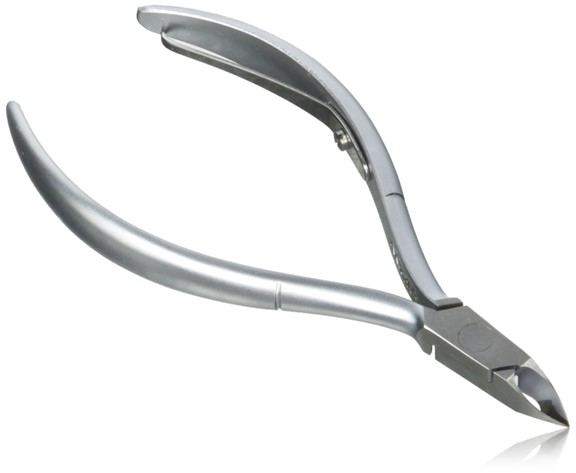 Tweezerman Cuticle Cutter tool resting on nail station in New York